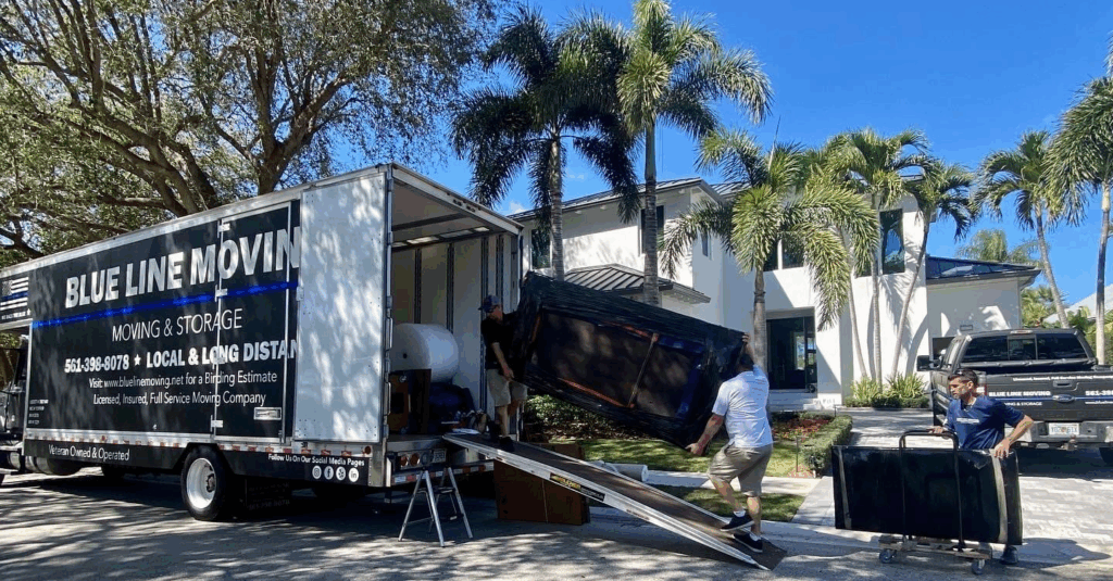 men moving furniture into a blue line moving truck