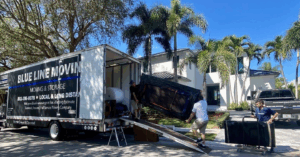 men moving furniture into a blue line moving truck