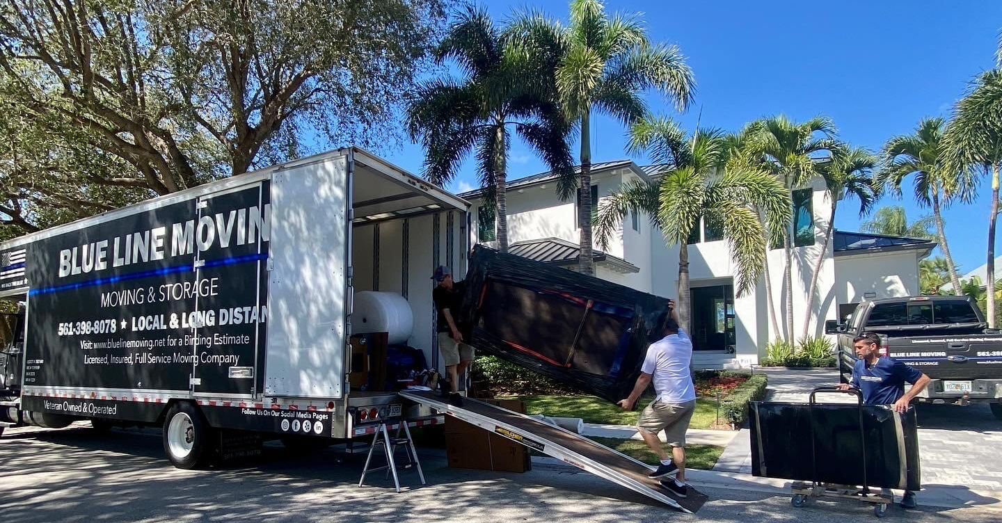 men moving furniture into a blue line moving truck